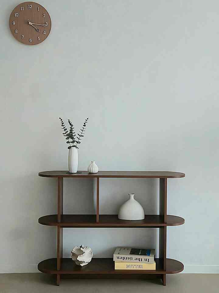 Minimalist living room cabinet space featuring wood tone shelves and white decorative objects