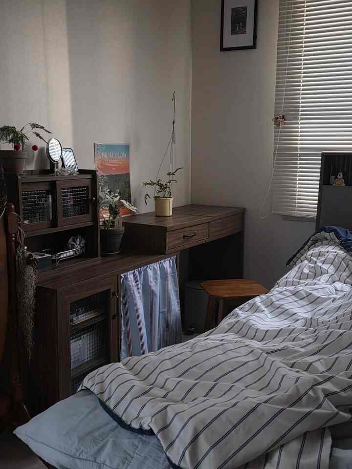 木目調のナチュラルカラーが調和した寝室、ベッドと化粧台が効率的に配置された印象的な空間