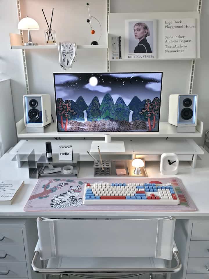White and gray toned home office featuring a central monitor and keyboard on a simple desk setup