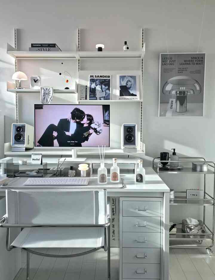 ホワイトトーンのホームオフィス空間、ミッドセンチュリーモダンのアームチェアと整然としたディフューザーが配置されたモダンな書斎インテリア