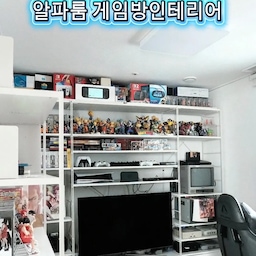 #콘수프필름 #알파룸인테리어 #게이밍책상 #게임방 #만화책장 #만화방 
이번에 새 집으로 이사하면서 가장 공을 들였던 공간 중 하나인 '남편방 꾸미기' 결과물을 공유해 보려고 해요.
사실 이사 전부터 남편의 유일한 취미인 게임과 수집품들을 어떻게 배치할지 고민이 참 많았는데요. 이번 집에는 '알파룸'이 있어서 이곳을 온전히 남편만을 위한 게임룸으로 꾸며주기로 결정했답니다.
공간이 일반 방보다는 조금 아담한 편이지만, 남편의 보물들을 알차게 채워 넣으니 오히려 아늑하고 집중력(?) 높은 완벽한 아지트가 되었어요.
그럼, 게임방 인테리어의 정석! 하나하나 소개해 드릴게요. ㅎㅎ
