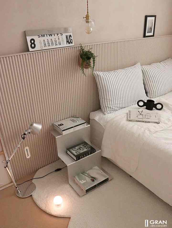 温かみのあるベージュトーンの寝室、白い寝具とシルバーのメタルナイトテーブルが調和したモダンで上品なインテリア