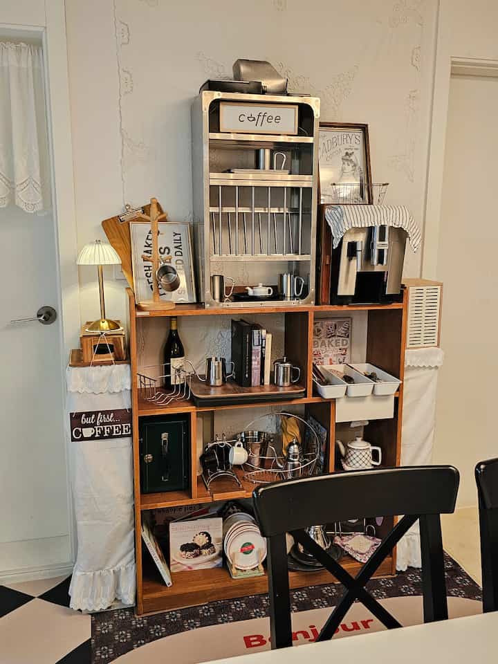 木目調のキッチン兼ホームカフェ、コーヒーマシンとステンレス製キッチンラック、ヴィンテージ小物が配された温かみのある空間