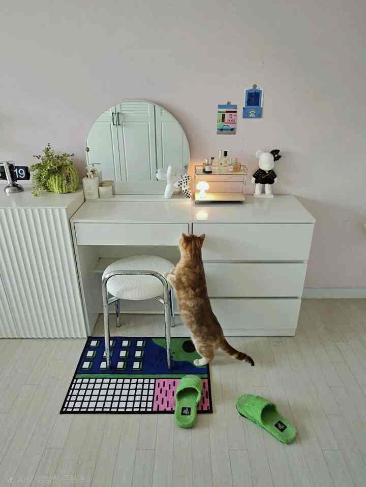 ホワイトとパステルピンクの色調の子供部屋、化粧台とスツール、猫がいる雰囲気のあるインテリア