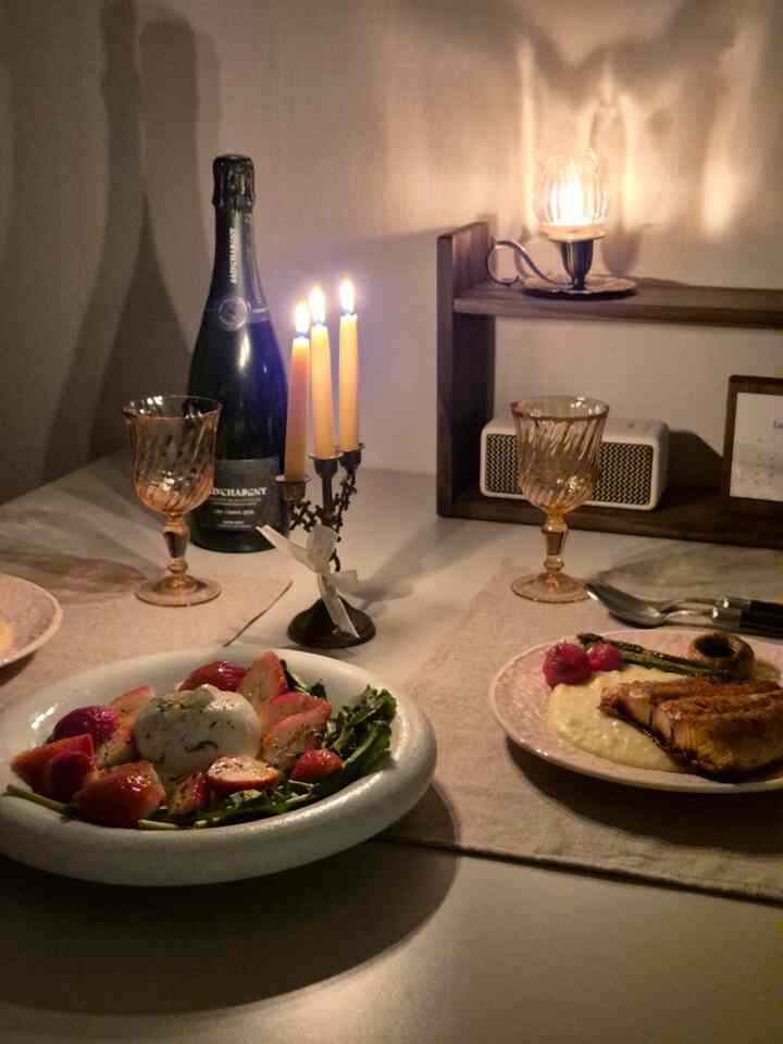 暖かいブラウン調のダイニングルーム、テーブルにワイングラスやカトラリー、キャンドルが配置され、雰囲気のあるインテリア