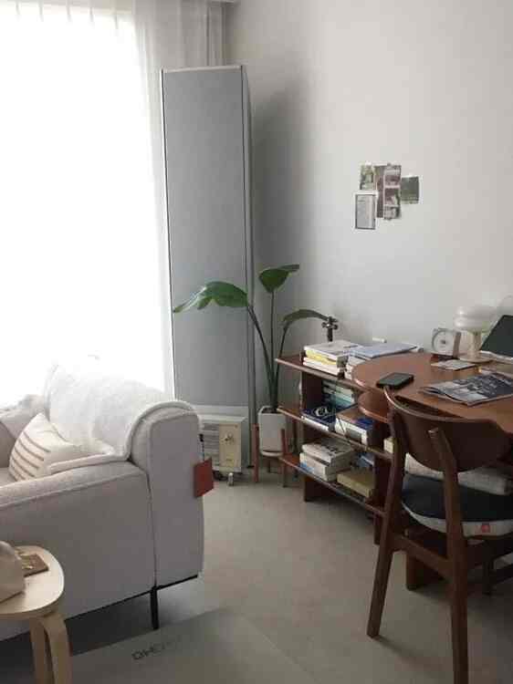 白を基調とした2人暮らし用リビング、ブラウンのダイニングテーブルと本棚が配置された清潔感のある空間