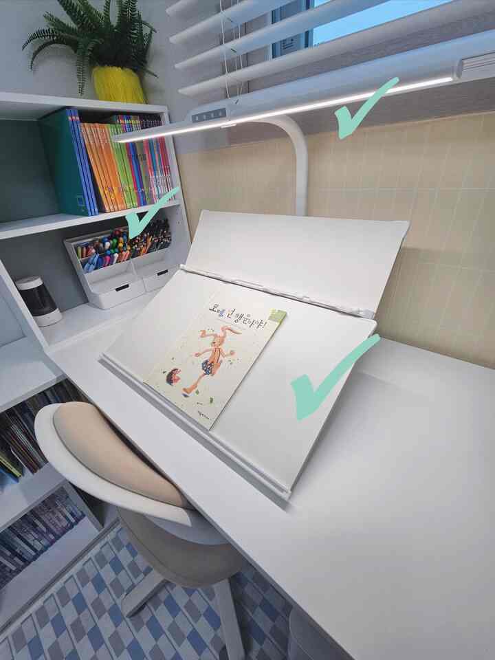 白とベージュのトーンが特徴のホームオフィス、ブックスタンドとLED照明が備わった清潔感あるデスク環境