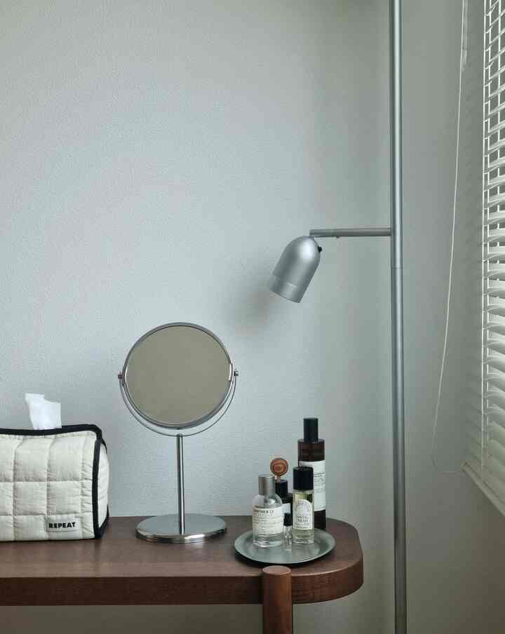 シルバーの鏡とスタンドランプがあるブラウンテーブルの清潔な化粧台空間