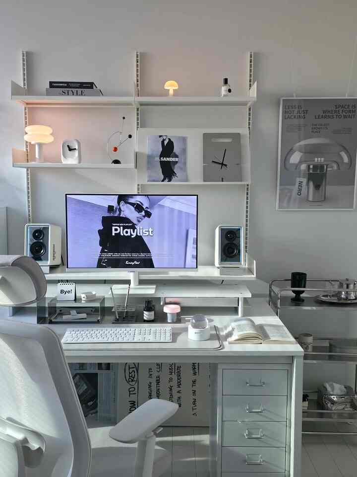 白を基調としたホームオフィス空間、広いデスクに電子ディフューザーとモニターが配置された清潔感あるモダンなインテリア