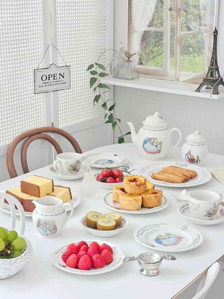 明るく白を基調としたキッチンダイニング、ピーターラビットの食器と多彩なデザートが美しく盛り付けられたクラシックで温かみのあるインテリア