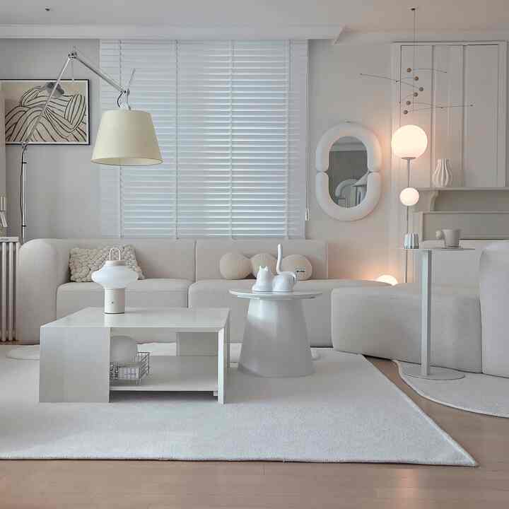 ホワイトトーンのリビング、コーナーソファと重ねられたリビングテーブルが配置された雰囲気のあるインテリア