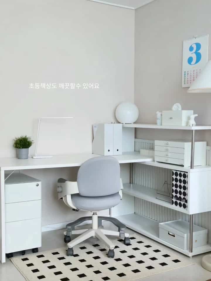 白を基調とした子供部屋の勉強スペース、整頓されたデスクと本棚が配置されたモダンな印象のインテリア