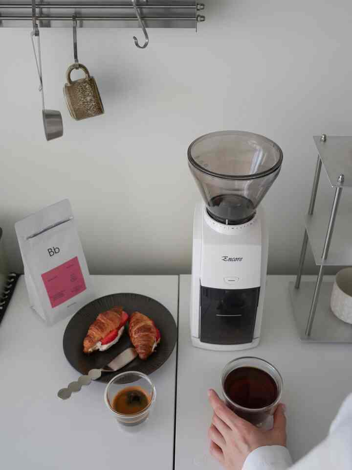 白を基調としたキッチンスペース、コーヒーグラインダーとクロワッサンが置かれたミニマルなおうちカフェ