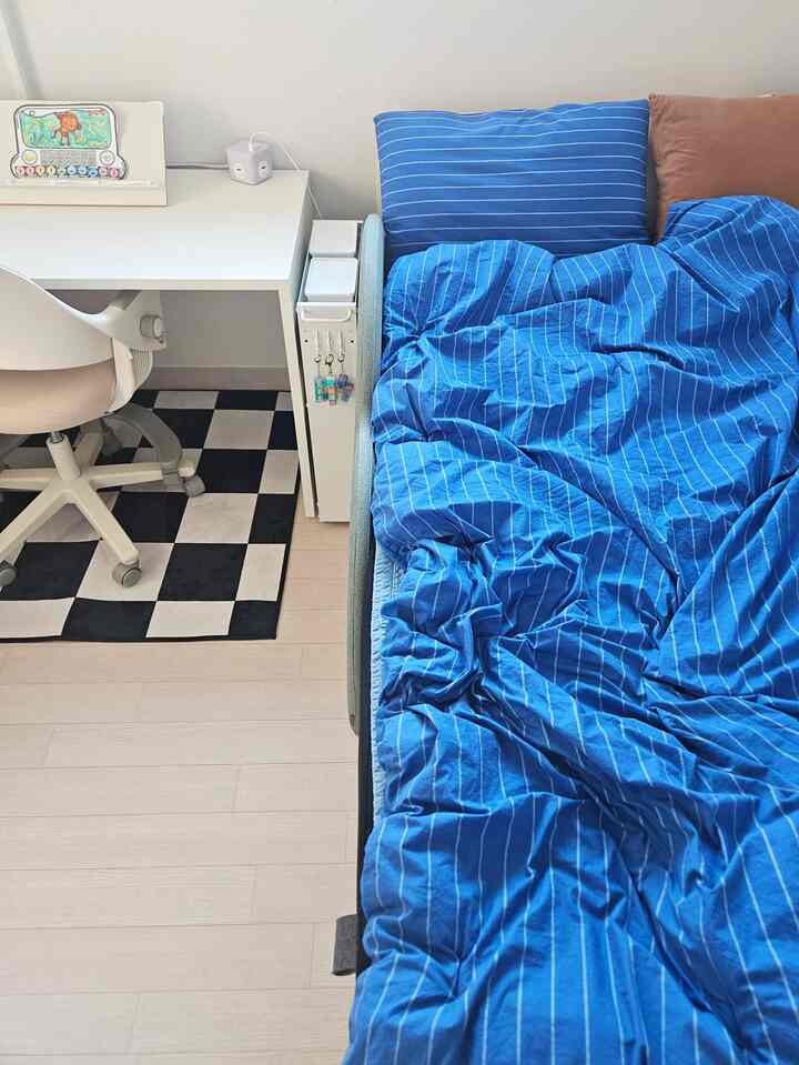 ブルーとホワイトの色調の子供部屋、机とベッドが配置された清潔でコンパクトな空間