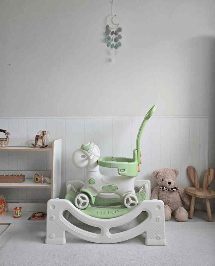 アイボリーと白を基調とした子供部屋、木製の玩具とラグが配置された雰囲気のある空間