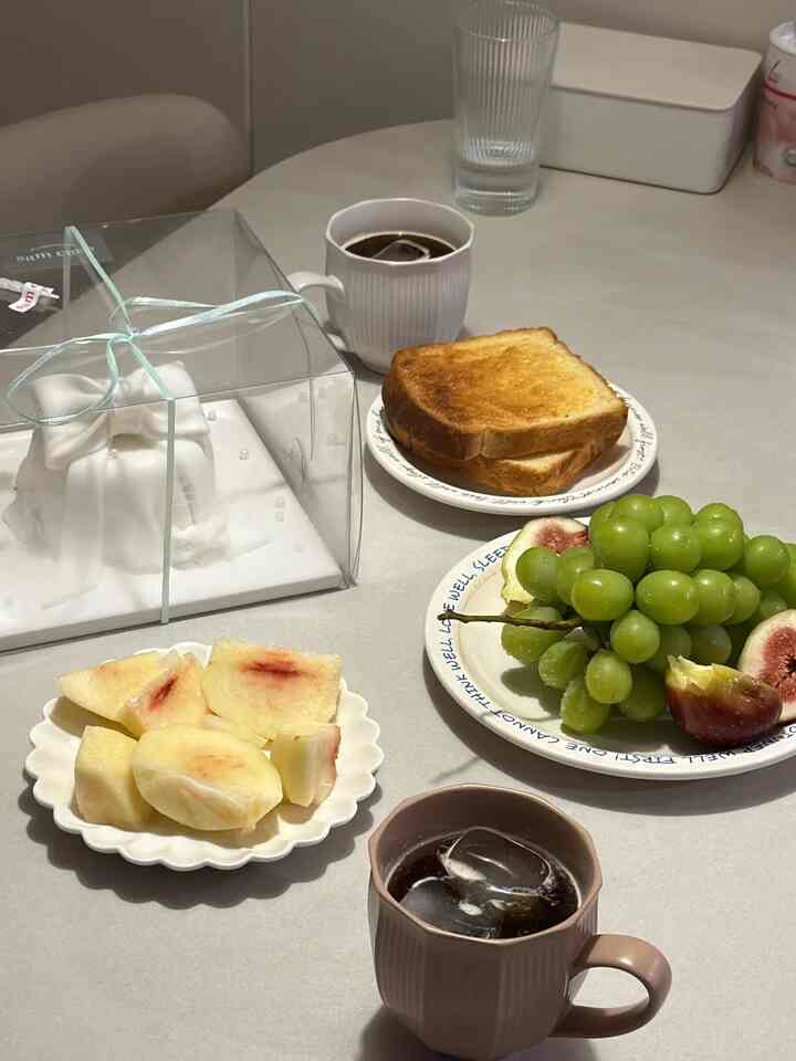 おいしい食事を終えた後、家々の火竜点情を飾る甘いデザートタイムをご用意しました！ 🤍

お客さんが直接買ってくださった綺麗なリボン飾りのケーキをメインに、旬を迎えた甘いジューシーでいっぱいの桃とタングルタングルのさわやかな青ぶどう、そしてイチジクまできれいな皿に盛り込んで盛り上げてみました。ここに焼きたての癖とカリカリのトーストと涼しいアメリカーノまで添えたので、まるで素敵な感性カフェに来たような雰囲気が演出されたんですよ。

甘いデザートをひとつずつ味わって時間が経つことができず、続く楽しいおしゃべりに、我が家のリビングルームにはモングルモングルで暖かい笑い声が絶えませんでした。大切な人たちと一緒においしいものを分けて食べて優しい心を満たしていくこの時間が本当の幸せではないかと思います。今後の私たちの新しい始まりを一緒に祝ってくれてありがとうの人々との忘れられないきれいな夜です。  #청첩장모임 #집들이 #디저트타임 #과일플레이팅 #홈카페 #신혼집들이 #신혼부부일상 #온더테이블 #소소한행복 