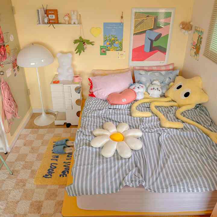 Cozy bedroom with yellow walls featuring cute cushions and plush toys, evoking a playful kids' room atmosphere