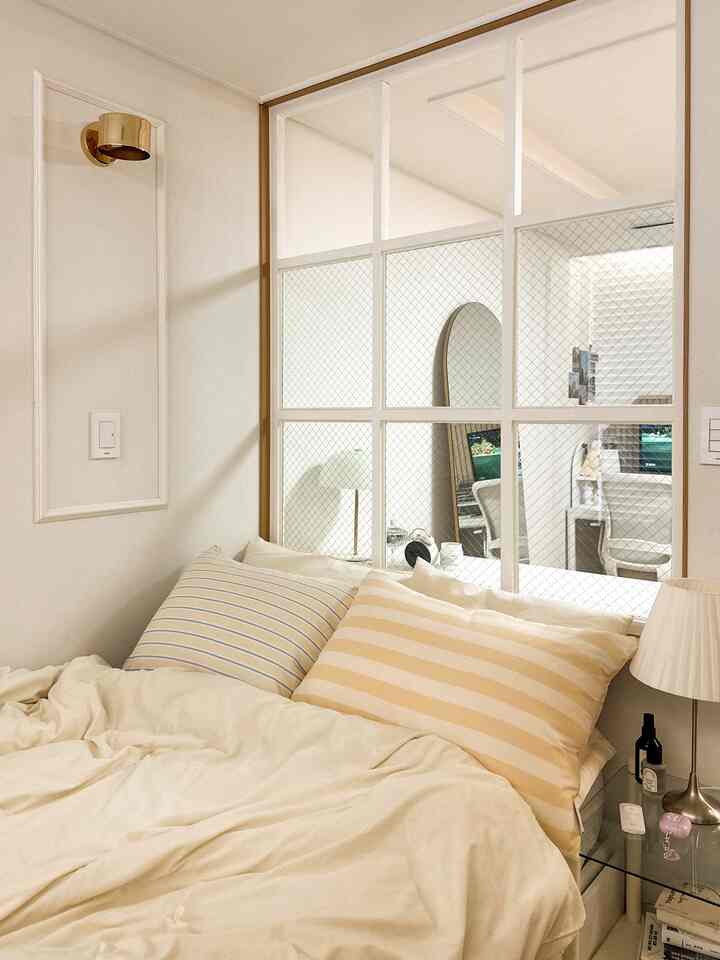 Ivory bedroom featuring yellow striped pillows and simple hotel-like bedding creating a cozy atmosphere