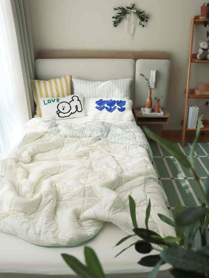 白と淡い緑の色調の子供部屋、木製のはしご本棚と柔らかなクッションが配置された居心地の良いインテリア