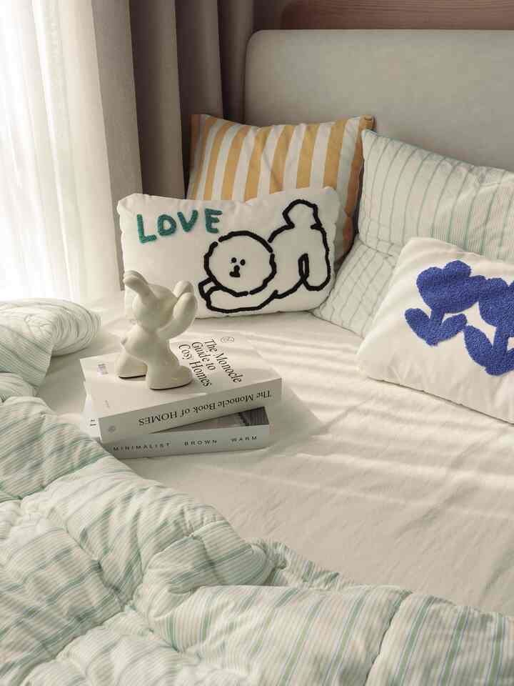 Natural toned kids' room featuring a fabric bed with various cushions in a cozy setting
