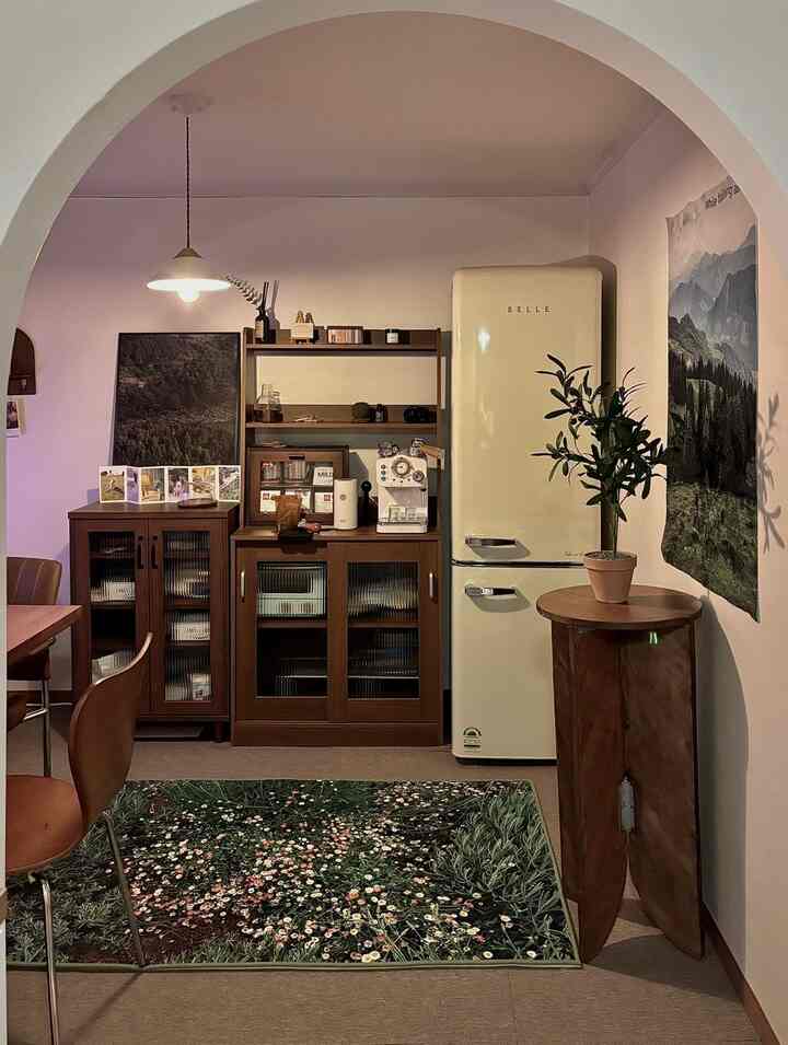 ベージュと木目調が調和した2ルームのダイニング空間、レトロな冷蔵庫と花柄のフロアマットが配置された雰囲気のあるインテリア