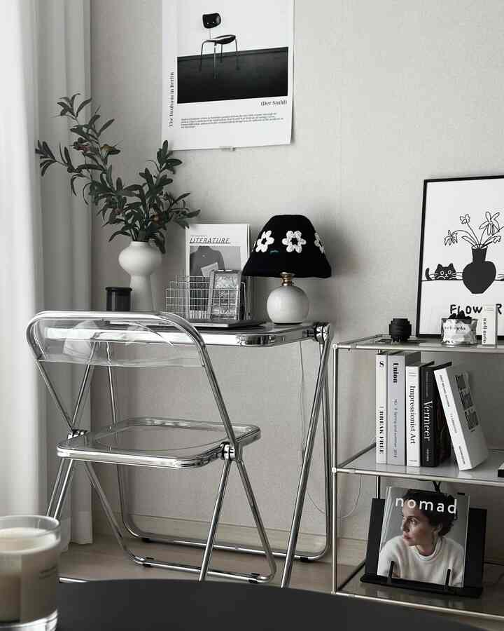 モノトーンとシルバーの調和が美しい、窓辺にあるリビングのシンプルで洗練されたデスクと椅子の空間