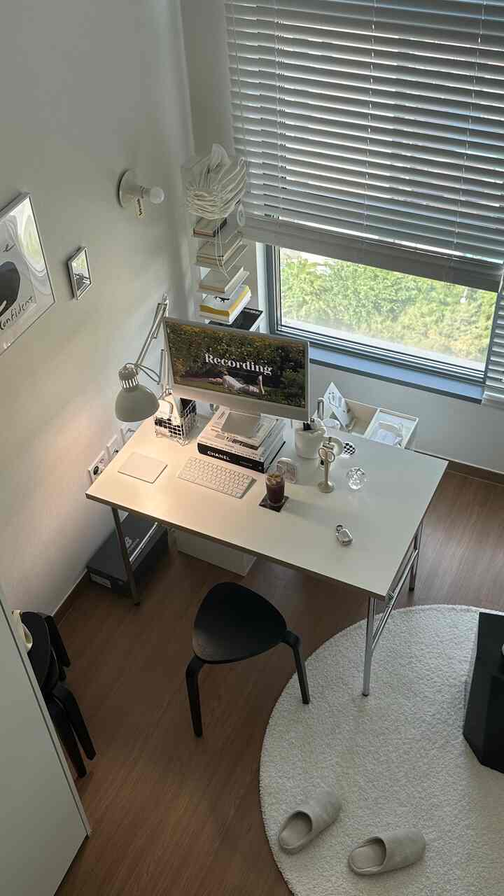 ホワイトとウッドトーンのミッドセンチュリーモダンなロフト型ホームオフィス、整った机とモニターがあるコンパクトな作業空間