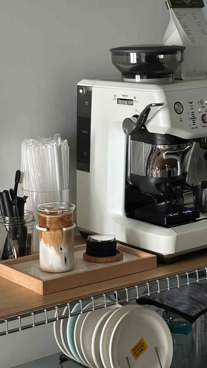 白を基調としたキッチン空間にブレビルのコーヒーマシンとアイスラテが配置された印象的なおうちカフェ