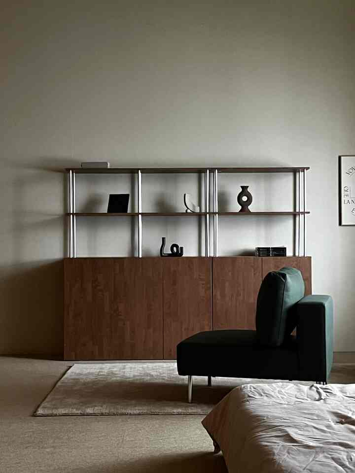 ナチュラルカラーのリビングルーム、木目調キャビネットと一人用ソファが配置されたヴィンテージ感のあるインテリア