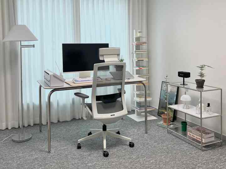 白とグレーのトーンの書斎空間、モダンなデスクとオフィスチェアが配置された清潔感ある在宅勤務環境