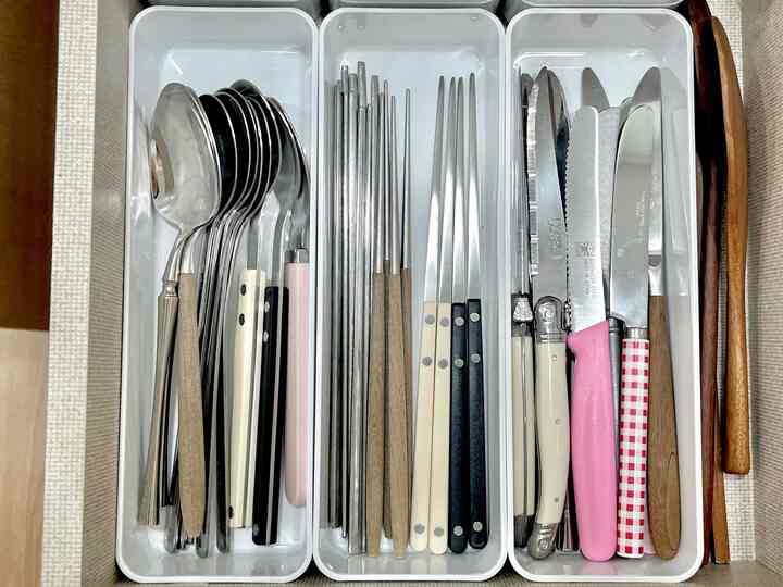 白いトレイにスプーン、箸、ナイフが整理されたキッチンの収納アイデア