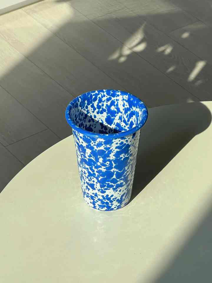 白いダイニングテーブルの上に青い斑点模様のクロウキャニオンのカップが置かれたモダンなキッチンスペース