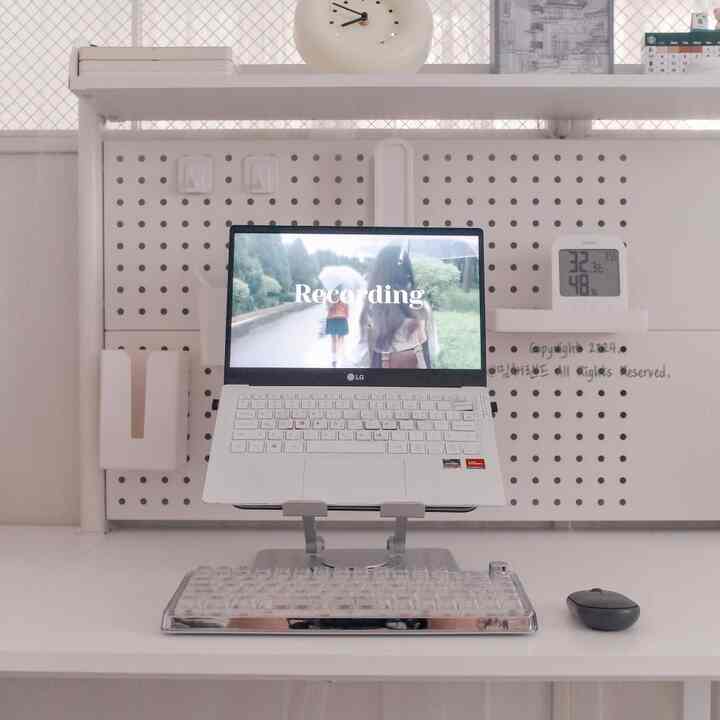 白を基調としたコンパクトなホームオフィス、ペグボードとノートパソコンスタンドが配置されたシンプルなデスク空間
