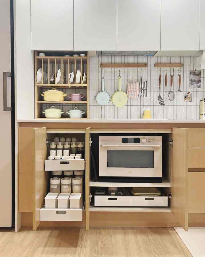 木目調と白が調和したキッチン、整然と並べられた鍋やフライパン、キッチン用品が配置された雰囲気のあるインテリア