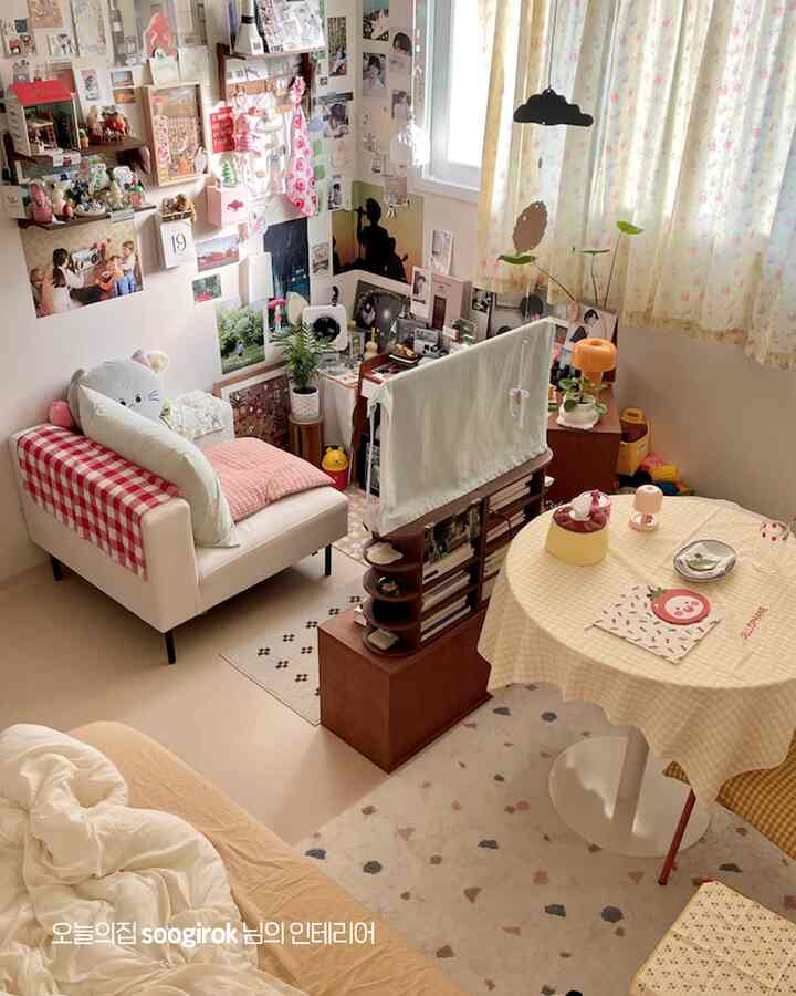 白と黄色のトーンが調和した4.5畳のリビング兼寝室、ソファとベッド、丸テーブルが配置された自然でヴィンテージ感のある印象的な空間