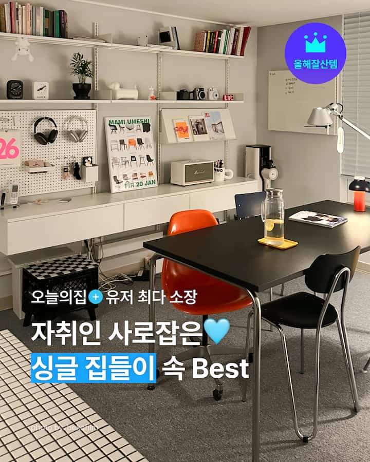 白と黒のトーンのワンルームダイニングスペース、モダンな家具と棚が配置された清潔感のあるホームオフィス兼食事空間