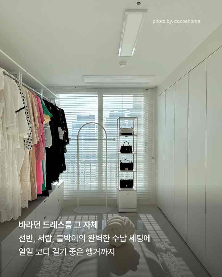 ホワイトトーンのウォークインクローゼット、すっきりとしたクローゼットと棚、色とりどりの服やバッグが整理されたモダンな収納空間