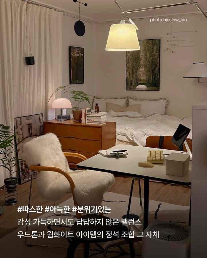 木目調とアイボリーのワンルーム寝室、デスクとアームチェア、暖かな照明が調和した雰囲気のあるナチュラルなインテリア