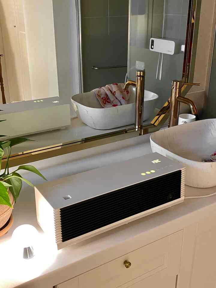 A white and gold-toned bathroom featuring a large mirror and elegant faucets with a sleek vanity setup