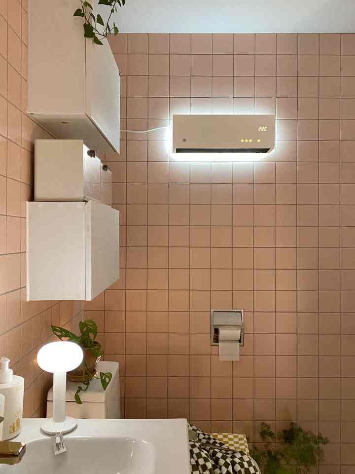 Clean bathroom space with warm pink tiled walls and white fixtures creating harmony