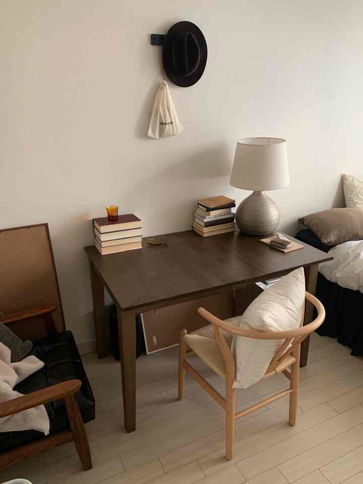 ブラウンとアイボリー調のワンルーム寝室、木製デスクとチェアが配置された自然で落ち着いた雰囲気のホームオフィス