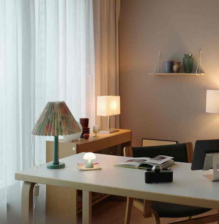 Natural color tone wood-toned home office featuring a simple modern desk and table lamps in a cozy atmosphere