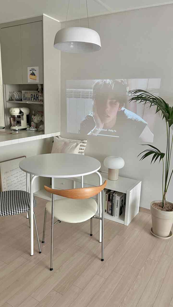 ナチュラルな木目調の床と白い壁、円形テーブルとイケアのベンチが配置されたモダンなキッチンスペース