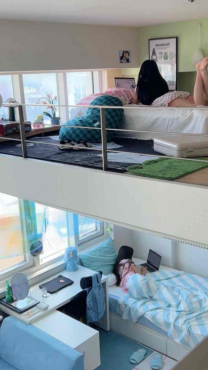 スカイブルーと白を基調とした二人用寝室、ロフトベッドとデスク、ラグやクッションが配置されたあたたかく爽やかな雰囲気のインテリア