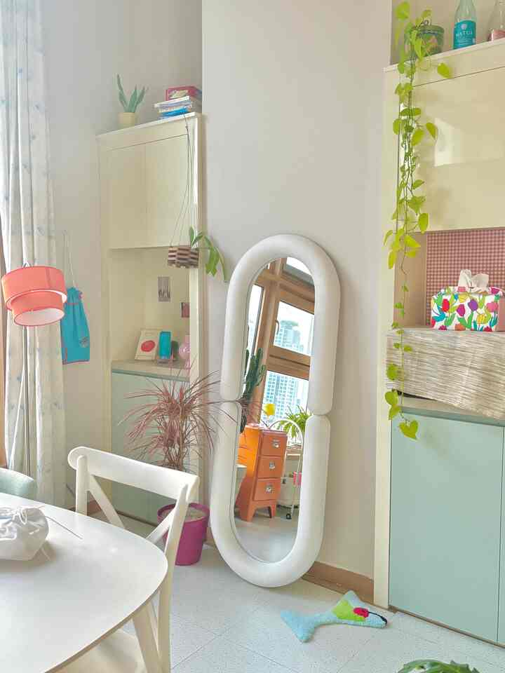 ホワイトの色調のリビングルーム、全身鏡とダイニングチェアが配置された落ち着いた自然な雰囲気のインテリア