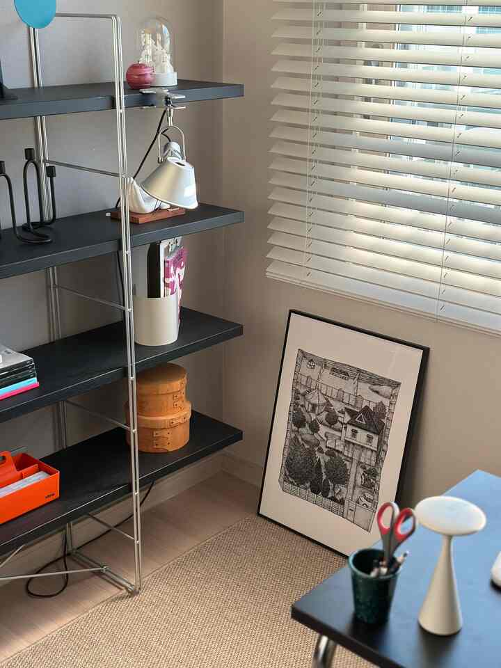 Natural and beige-toned study space with bookshelf and framed poster, creating a calm and organized atmosphere