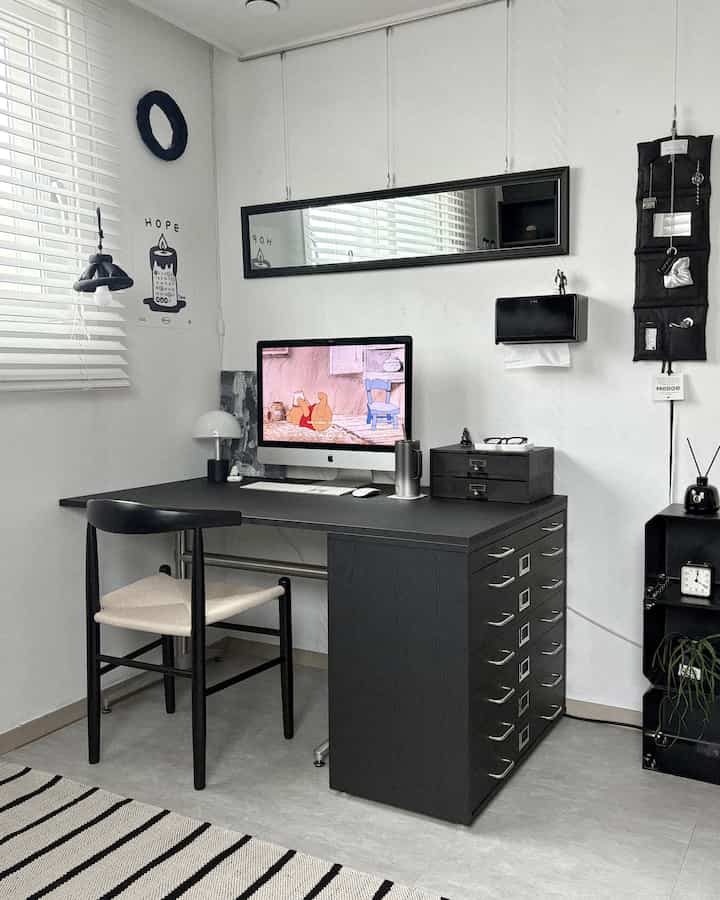 モノトーンで清潔感のあるミニマルなホームオフィス、黒いデスクと椅子が配置された洗練されたインテリア