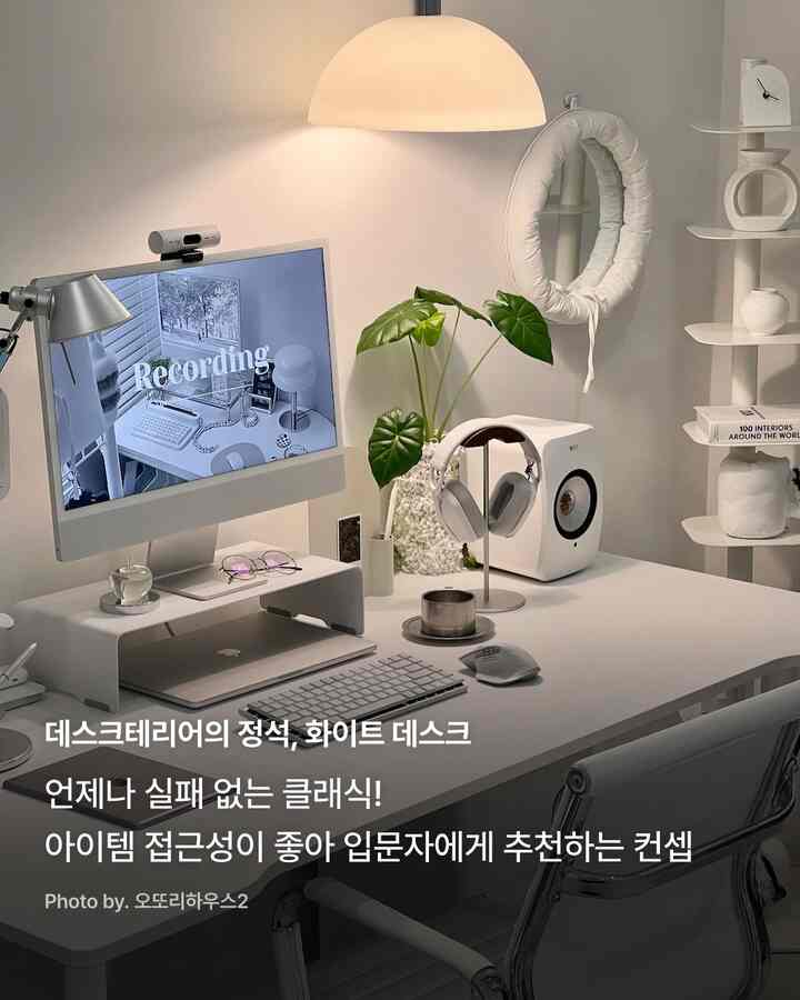 柔らかな白を基調としたミニマルなホームオフィス、モニター台とヘッドセットスタンドが整然と配置された空間