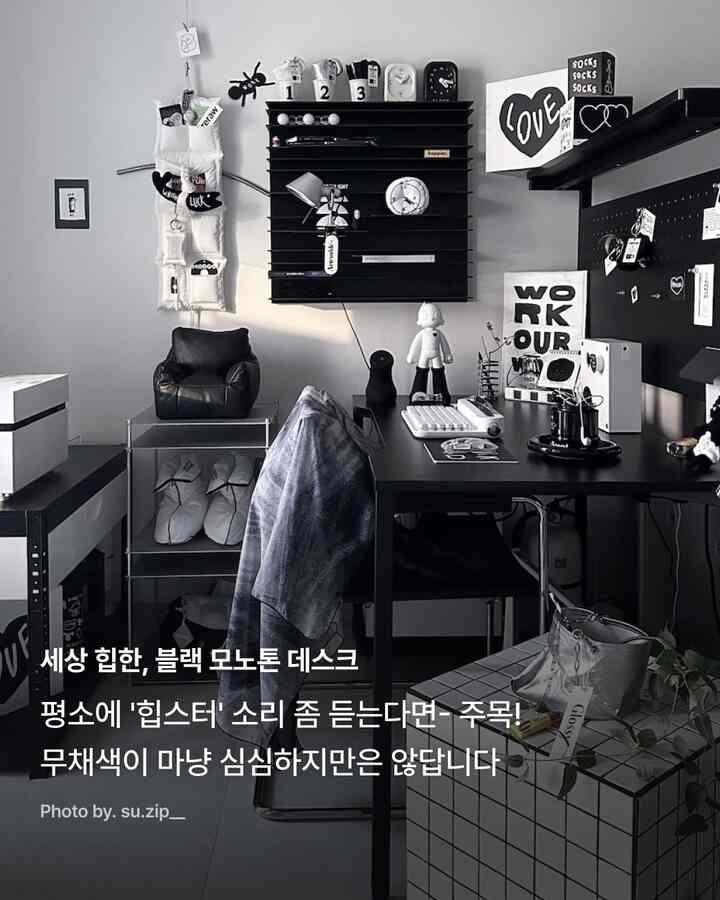 黒と白のモノトーンでまとめられたモダンなホームオフィス、机とアームチェア、棚が配置されて印象的な空間