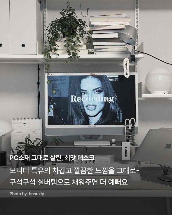 ホワイトとシルバーのトーンでまとめられた、棚とモニタースタンドが配置されたシンプルモダンなホームオフィス空間